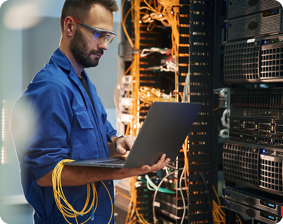 IT Professional working with cables and holding a laptop